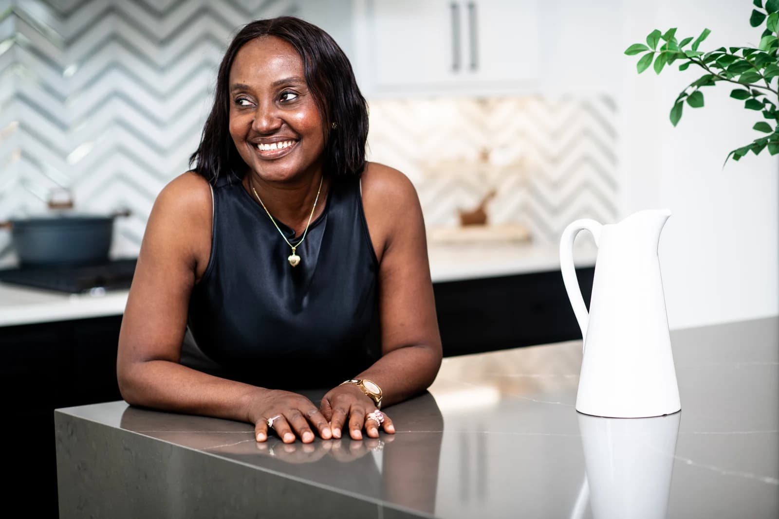 Esther Atere smiling at a kitchen island in a bright home